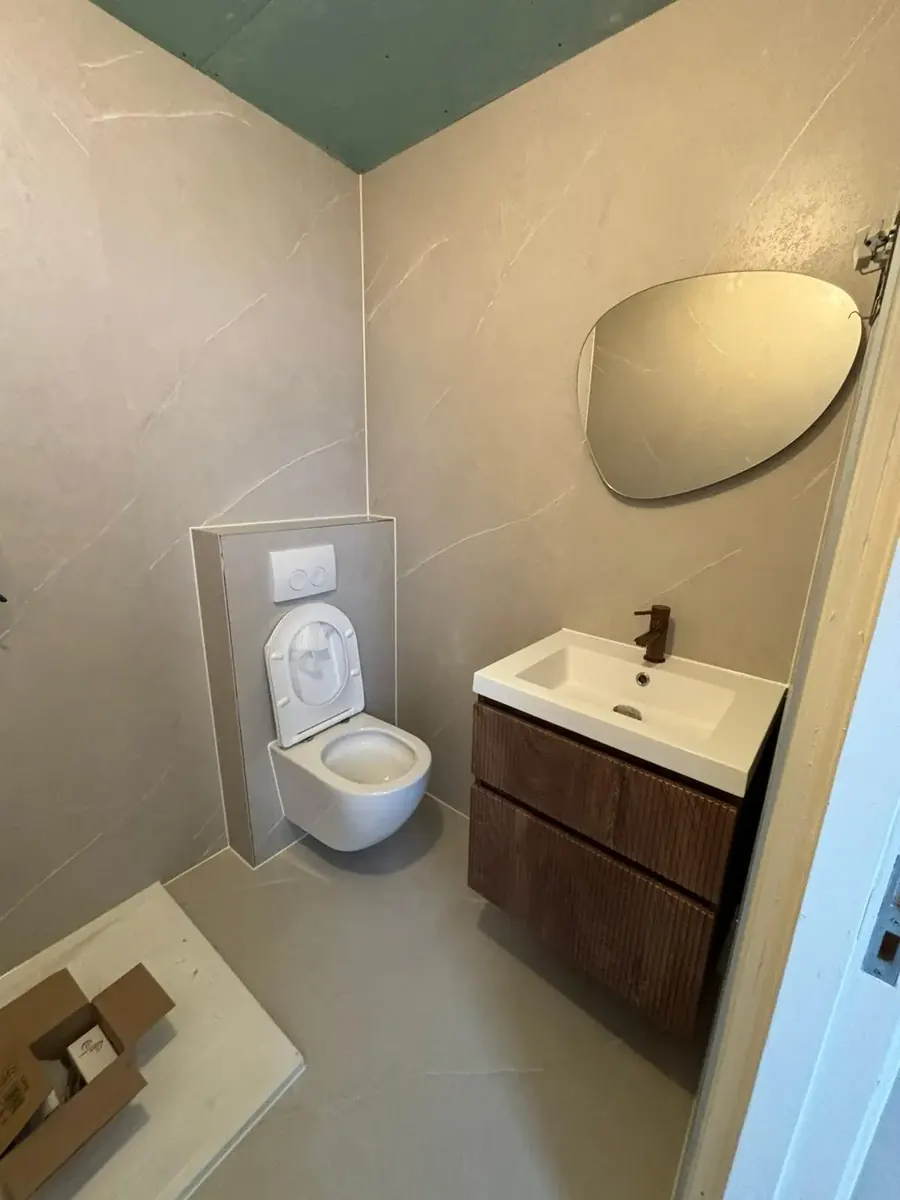 Toilet en wandpanelen in een vernieuwde badkamer
