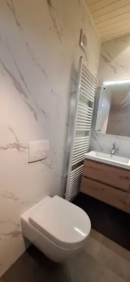 Badkamer met witte marmerlook en wastafelmeubel