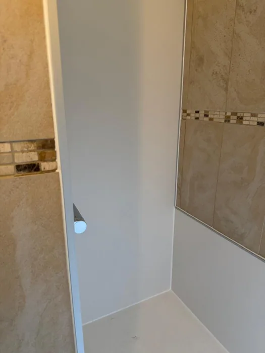 Douchenis met witte wandpanelen na renovatie
