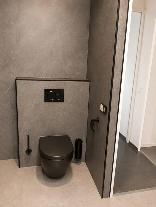 Zwart hangtoilet tegen een grijze wand in een badkamer