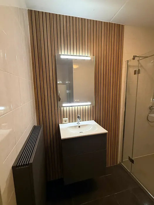 Badkamer met glazen douche en hangtoilet